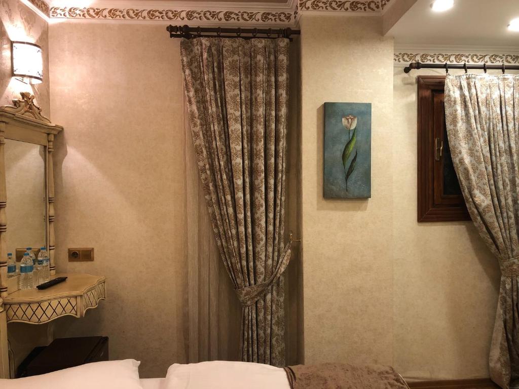 a bedroom with a bed and a window with curtains at Kaftan Hotel in Istanbul