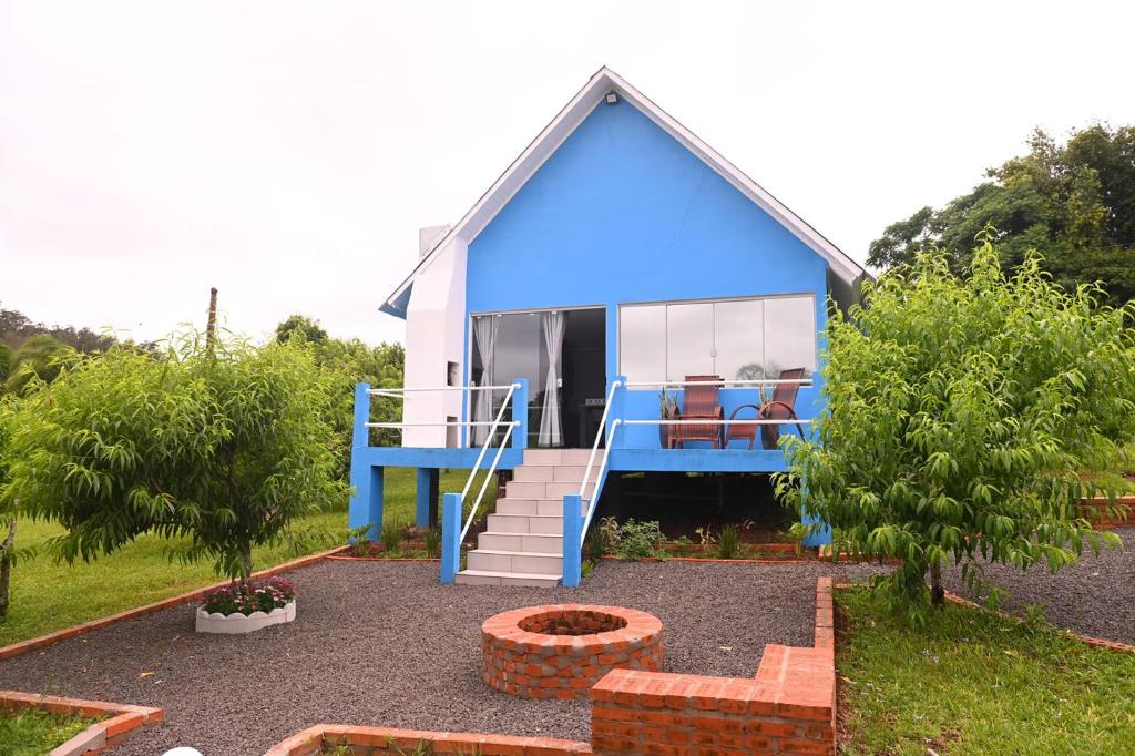 a blue and white house with a porch at Cabana Horizonte Azul com Hidro e Churrasqueira in Santa Rosa