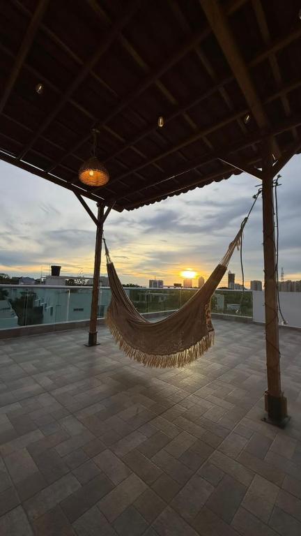 a hammock hanging from a roof with the sunset in the background at Cabaña Sisiguaca in Santa Marta