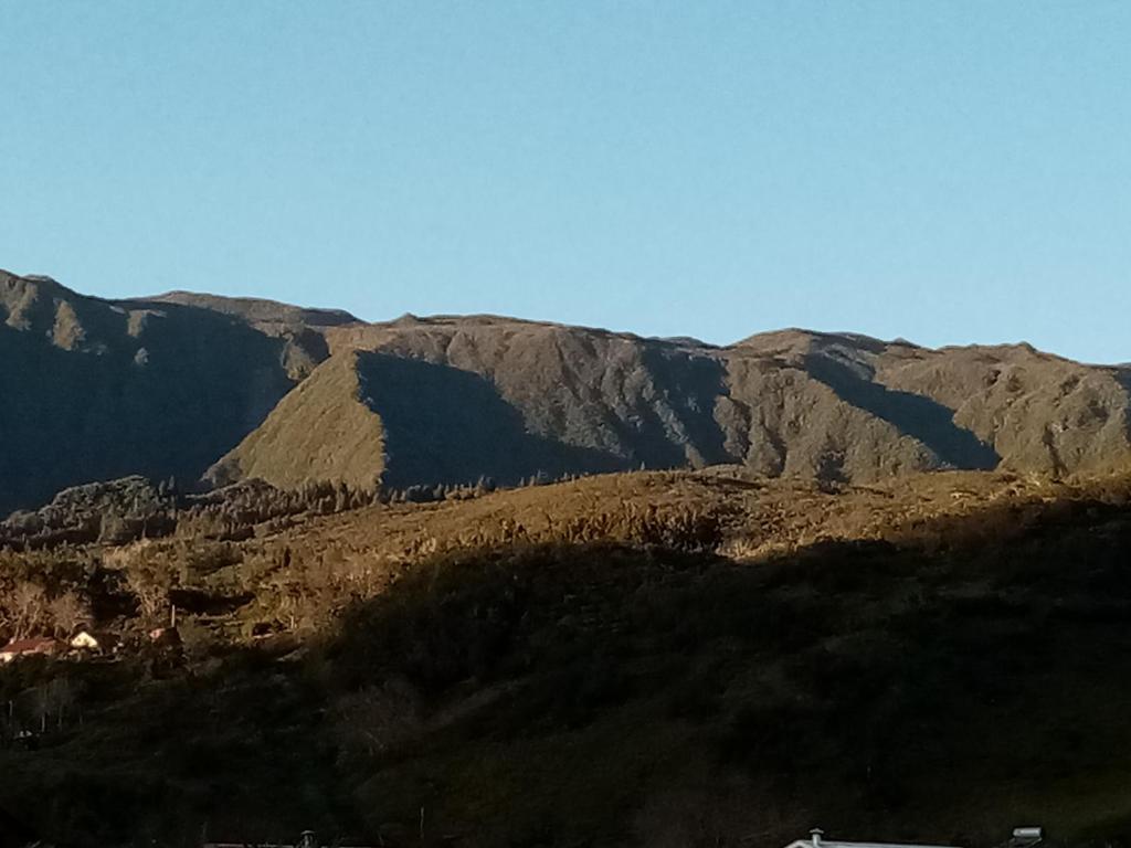 a view of a hill with mountains in the background at One in La Plaine des Palmistes