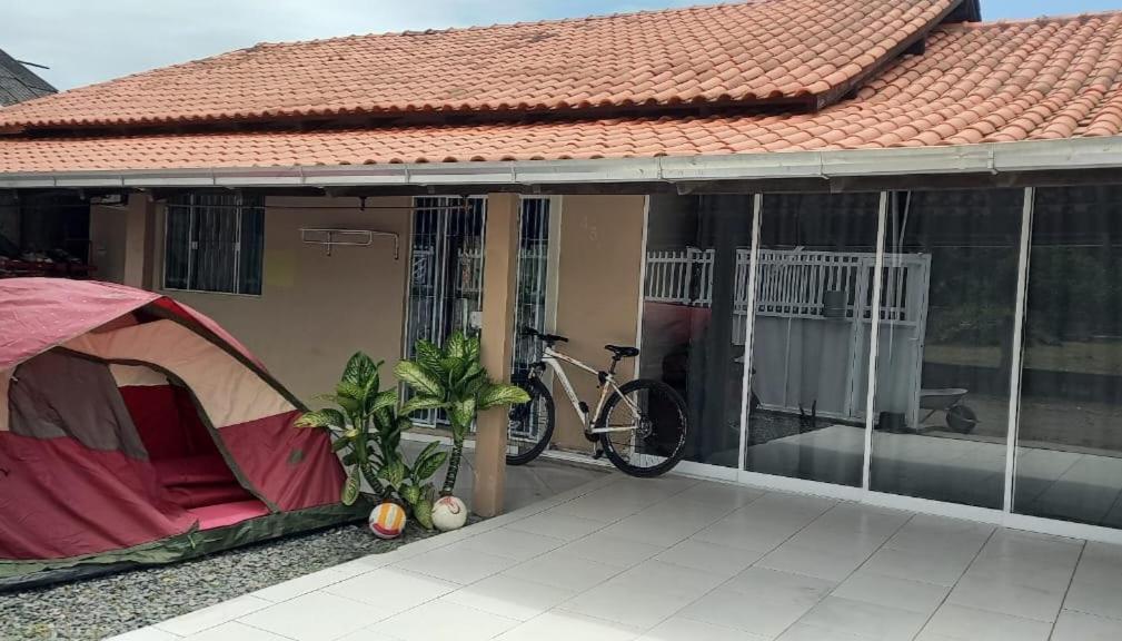 a tent on a porch with a bike on a house at HosteldaRo in Penha