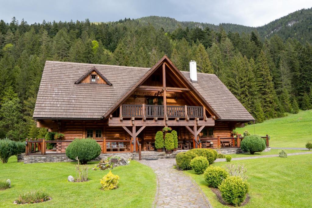 a log cabin with a porch and a balcony at Zrub Raj in Liptovský Ján