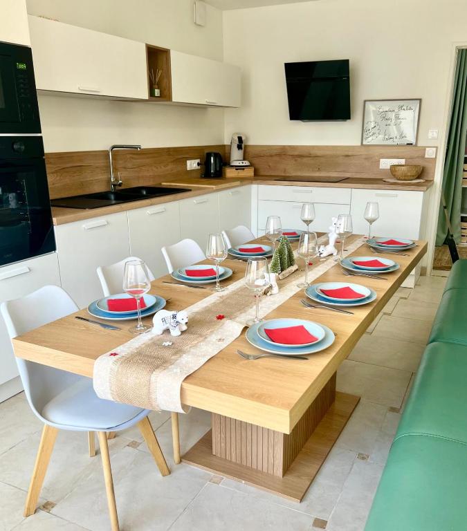 ルマンにあるAppartement 6 chambresの皿とワイングラスが置かれた木製のテーブルのあるキッチン