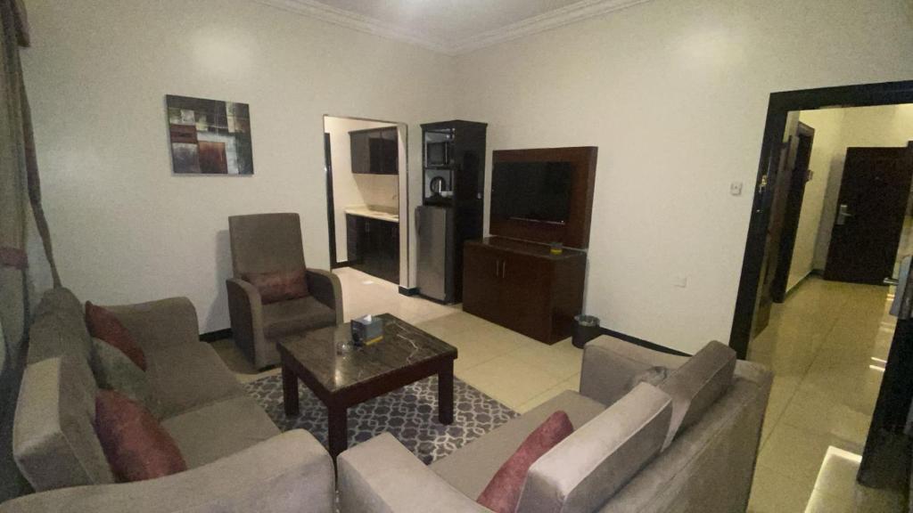 Una sala de estar con un sofá y un televisor en Almuhaidb Residence Al Malaz 6, en Riad