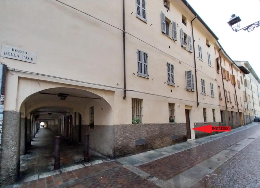 a large building with an archway next to a street at Borgo delle Colonne 22 in Parma