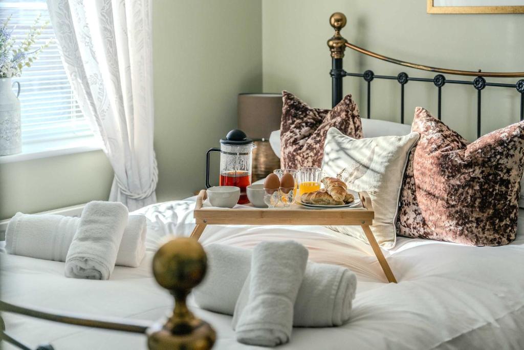 a bed with a tray of food on it at Spacious Cotswolds Base, Private Garden & Parking in Evesham