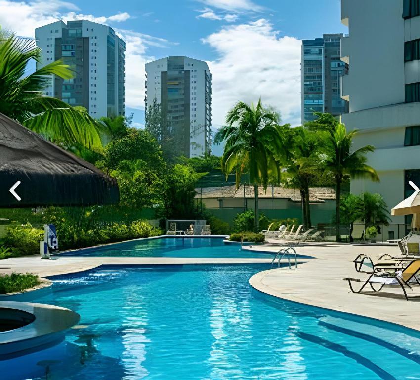 a swimming pool in a resort with tall buildings at Mediterrâneo Flat in Rio de Janeiro