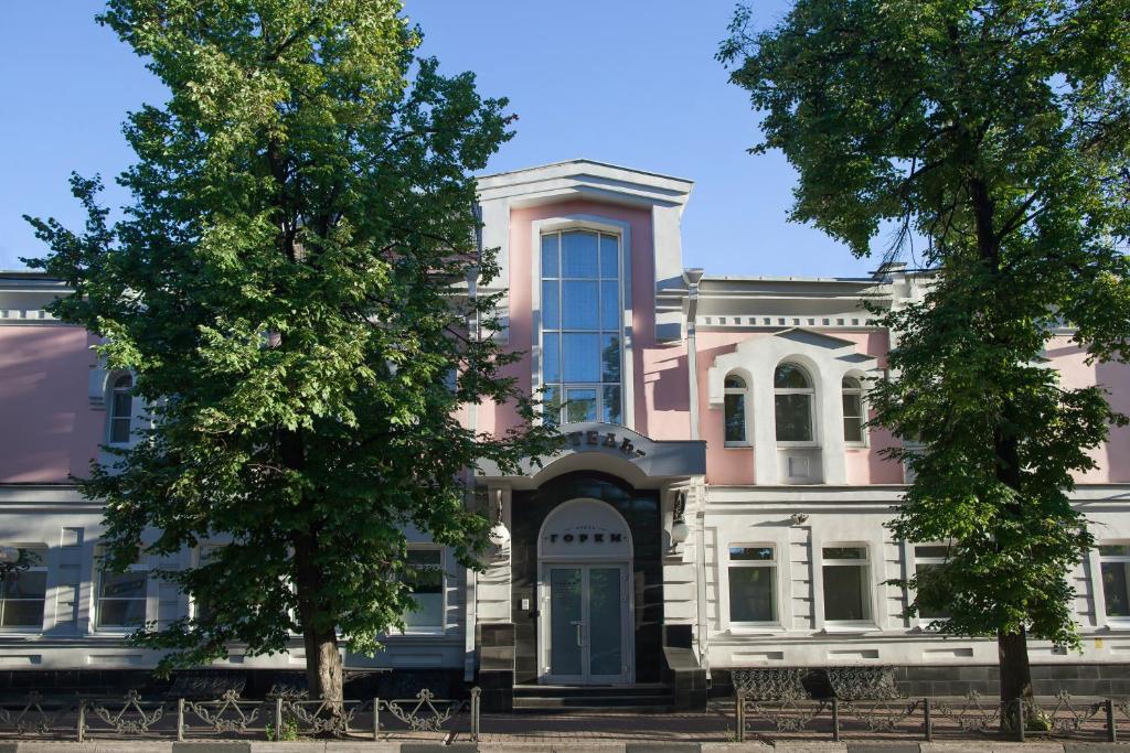 a pink and white building with trees in front of it at Gorky Hotel in Nizhny Novgorod