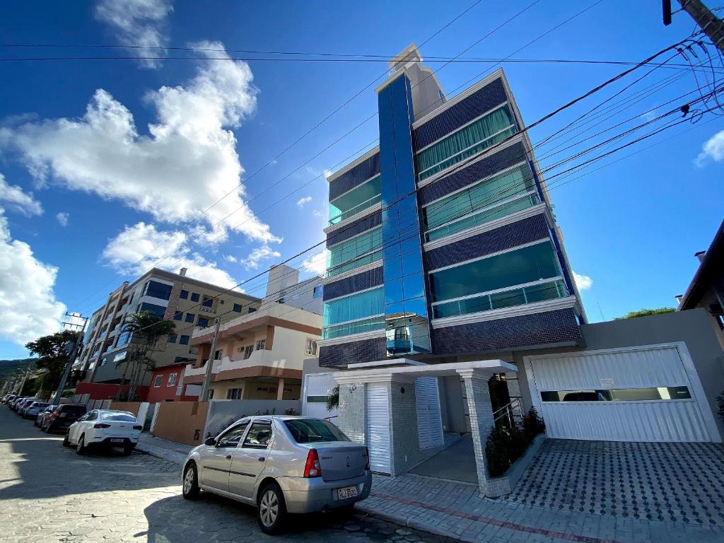 a car parked in front of a tall building at Vieques in Bombinhas