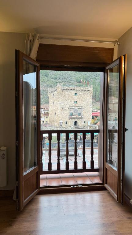 an open door to a balcony with a view of a building at Apartamentos La Solana in Potes