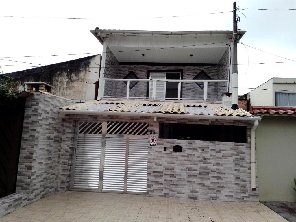 a brick house with a garage door in front of it at Pink house Enseada Beach in Guarujá
