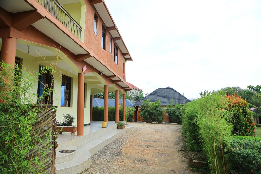 un edificio con una pasarela delante de él en Little Flowers Motel, en Fort Portal