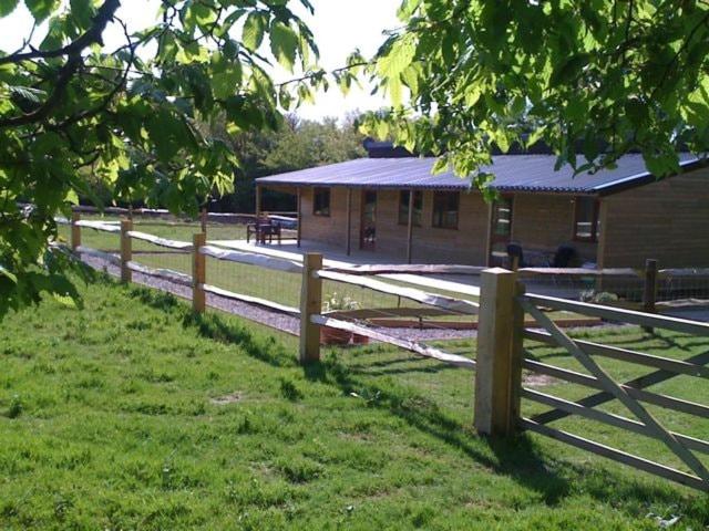 a wooden fence in front of a building at Woodside Cottages - Beech cottage - Self-catering in Fletching
