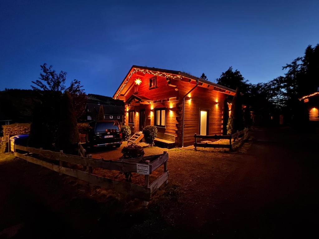 une cabane en rondins éclairée la nuit dans l'établissement Harz-Blockhaus, 4 und 5 Sterne, Sauna - und Kamin - KH, à Hahnenklee