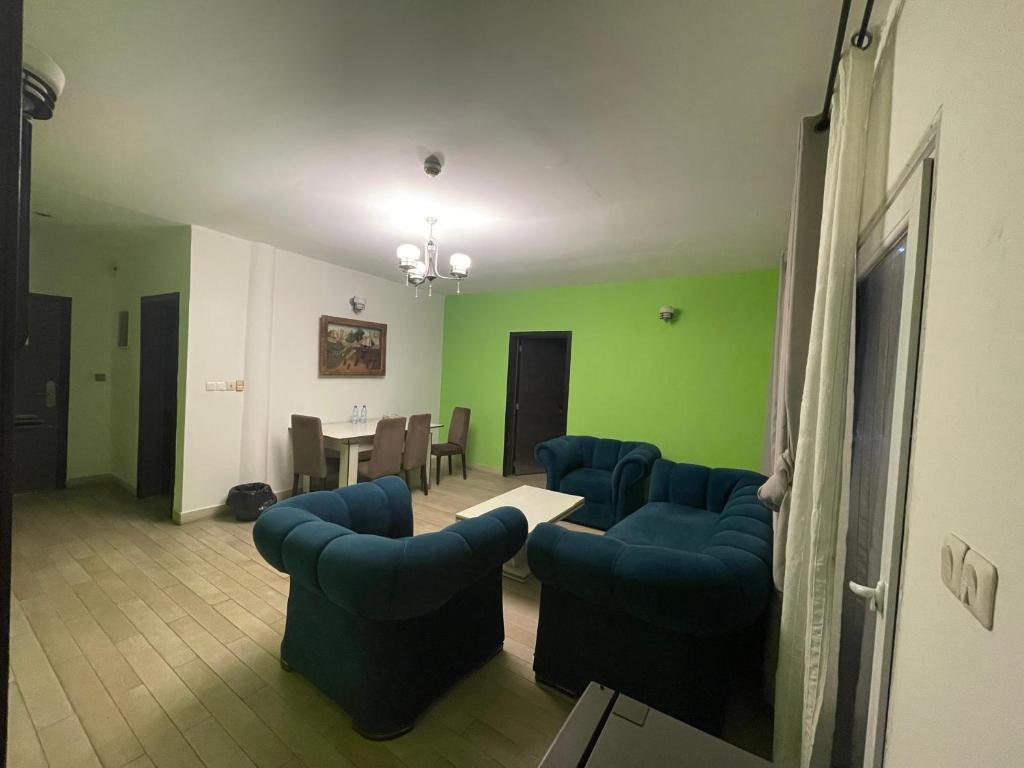 Una sala de estar con sillas azules y una mesa. en St Davido, en Douala