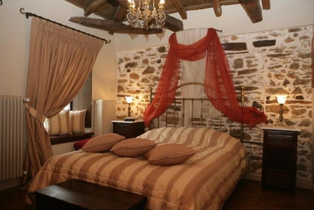 a bedroom with a bed with pillows on it at Archontiko Pantou in Portariá