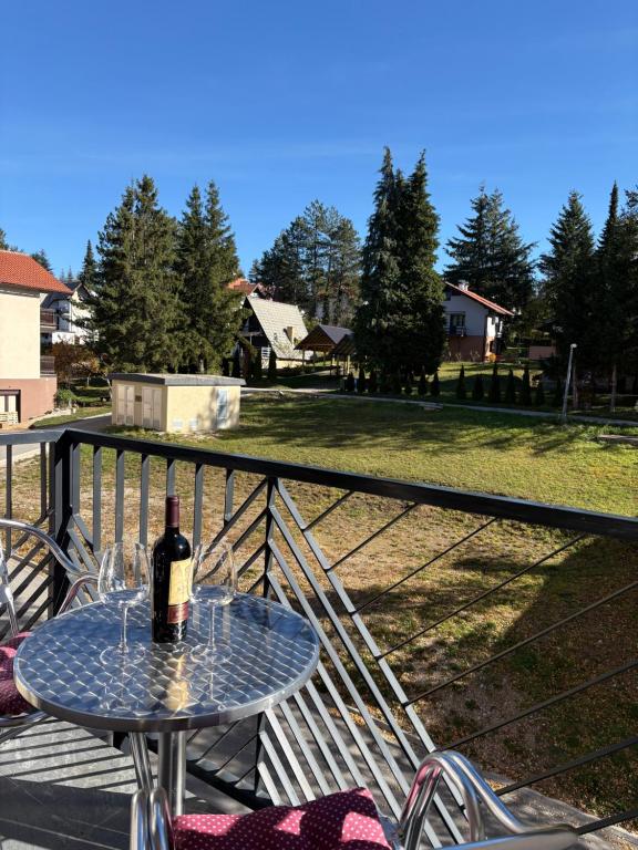 una bottiglia di vino seduta su un tavolo sul balcone di Magnet Lux Zlatibor 