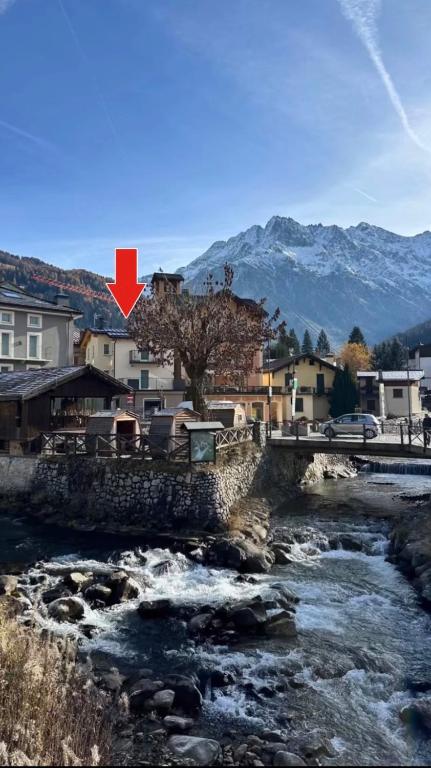 a river with a red cross in front of a city at Cusìcla Affittacamere in Ponte di Legno