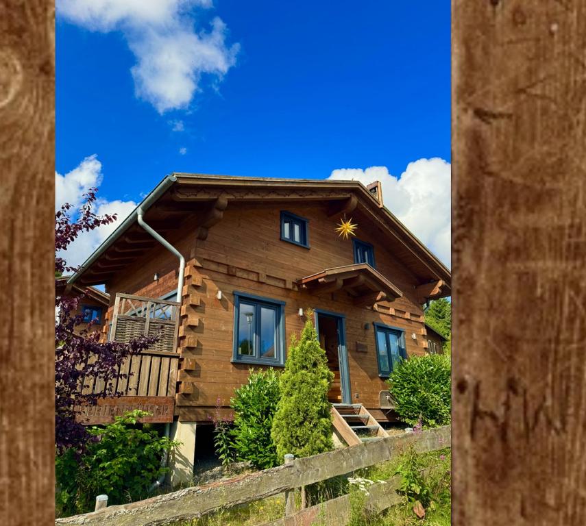 une maison en rondins avec une étoile sur le toit dans l'établissement Harz-Blockhaus, Berg -"Hütte" mit Sauna und Kamin, WH, à Hahnenklee