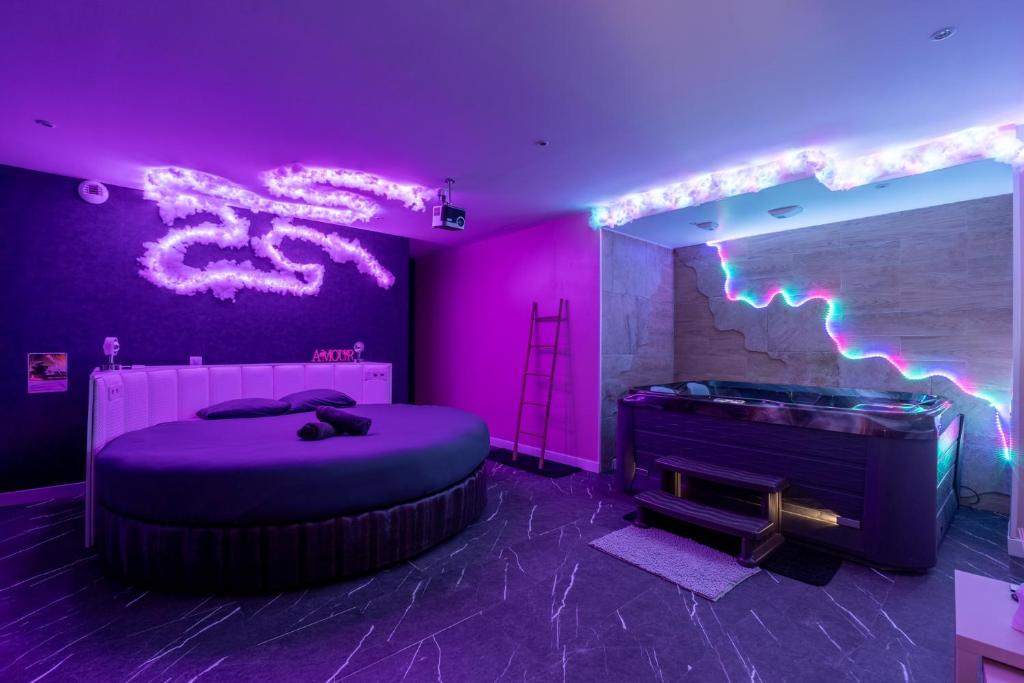 a purple room with a bed and a neon sign at Loft Paradis ~Jacuzzi privatif~ Séjour amour in Vieille-Toulouse