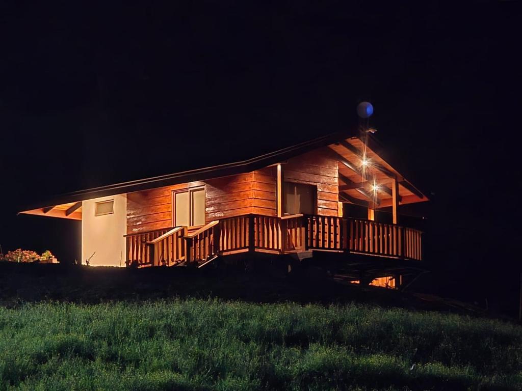 Cabaña de madera grande con terraza por la noche en San Vicente Mountain, en Colón