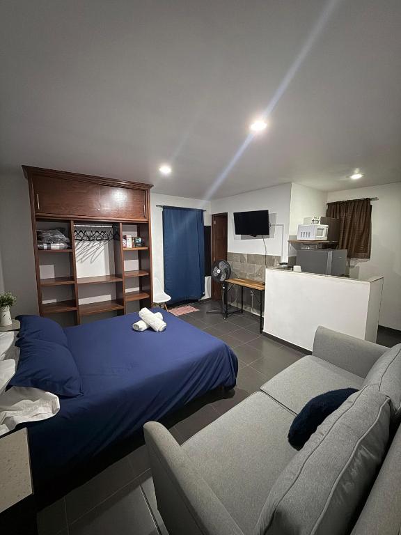 a bedroom with a blue bed and a couch at Lofts de Mexiamora in Guanajuato