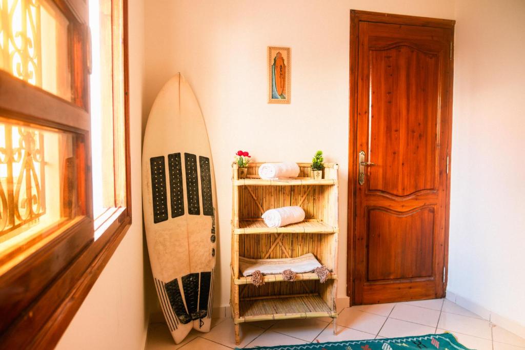 una habitación con una tabla de surf apoyada en una pared en Surf Away Morocco, en Agadir
