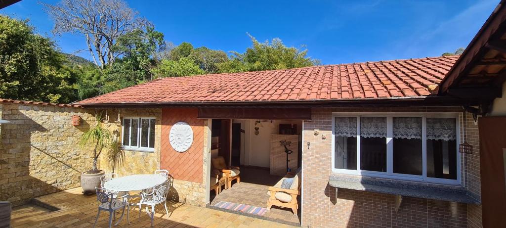 a small house with a deck with a table and chairs at Recanto do Nenei in Paraisópolis