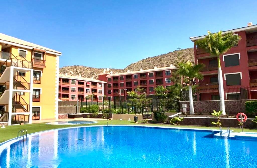 a swimming pool in front of some apartment buildings at Sil&Sol in Arona