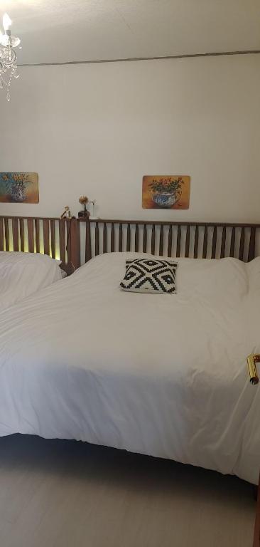 un letto bianco con due immagini sul muro di Urban a Suwon
