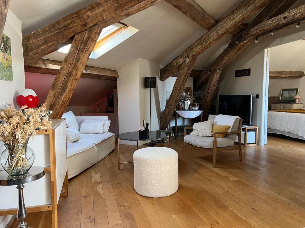 een woonkamer met een witte bank en een tafel bij Nid douillet sous les toits bourguignons in Dijon