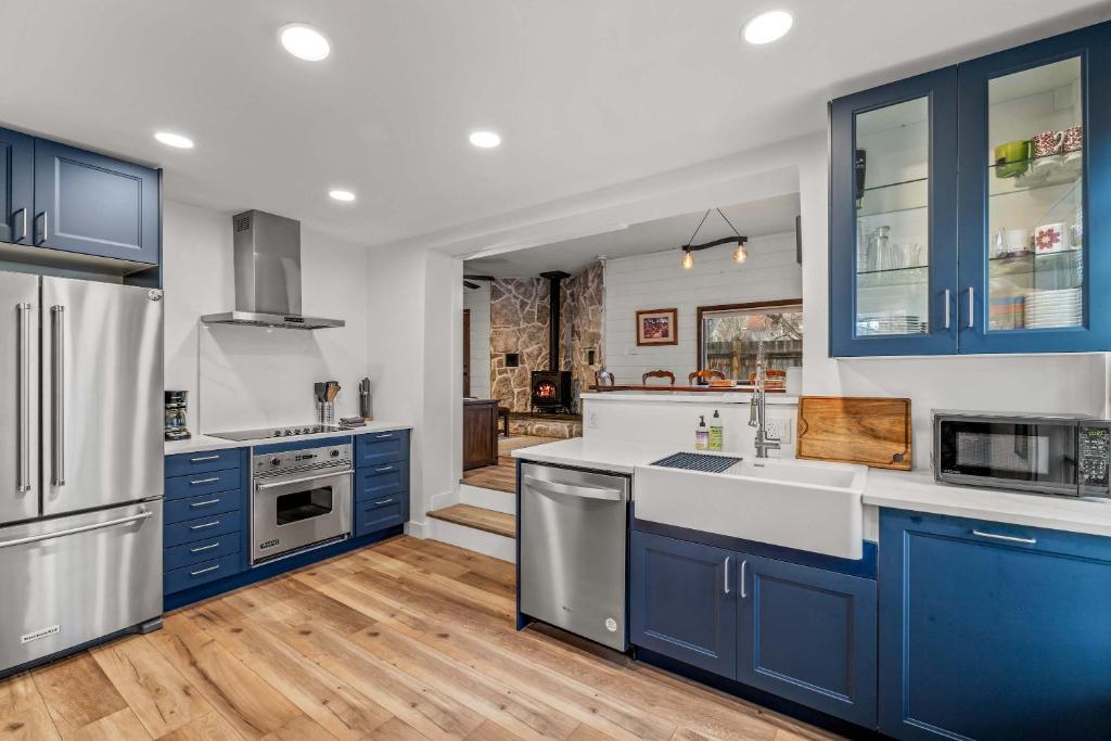 une cuisine avec des armoires bleues et des comptoirs blancs dans l'établissement Leif's Adventure Haus - Hot Tub - Downtown - Pet Friendly, à Steamboat Springs