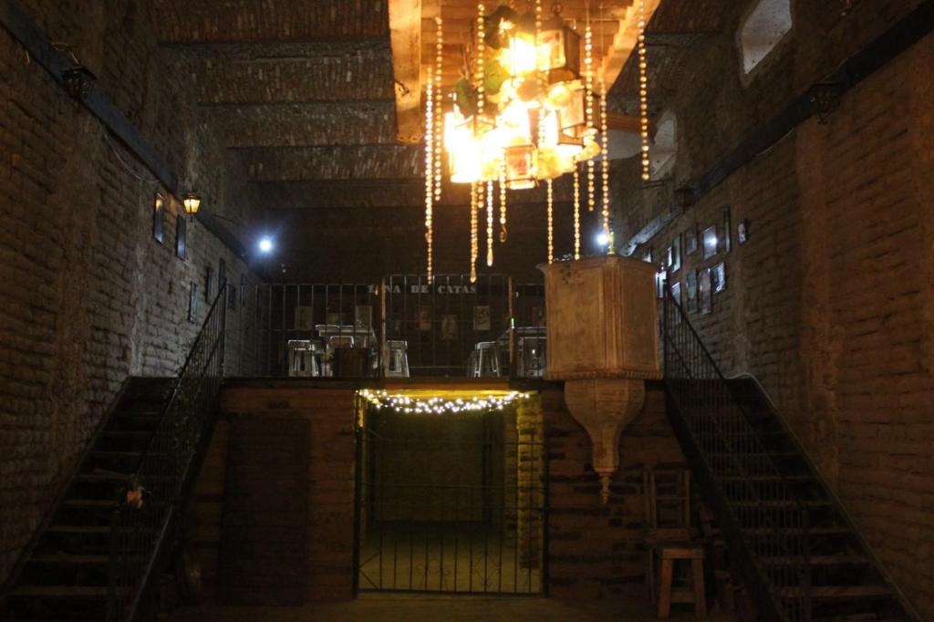 a room with a staircase and a chandelier at Cabañas Hacienda de Letras in Pabellón de Arteaga