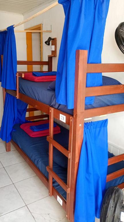 Dos literas en una habitación con sábanas azules. en Hostel casa da ana, en Búzios