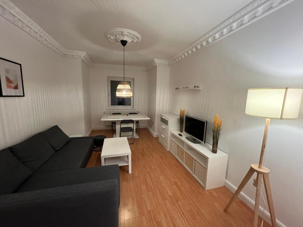 BremerhavenLuxus Apartment im Goetheviertel mit Badewanne, Regendusche WLAN uvm的客厅里有一张黑色沙发和一张桌子