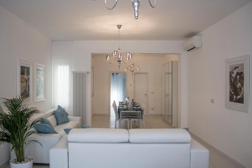 a living room with a white couch and a dining room at Artist's suite in Bari