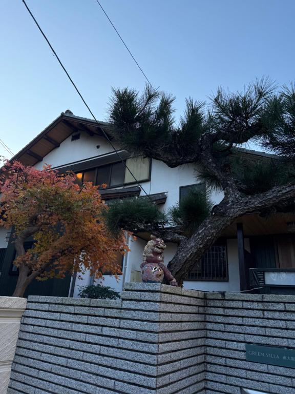a statue sitting on top of a wall next to a house at GREEN ViLLA南大阪 in Mikkaichi