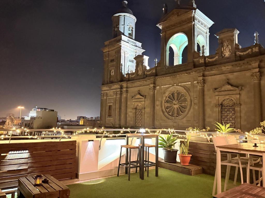 Santa Ana Suite & Rooms في لاس بالماس دي غران كاناريا: مبنى كبير به برج ساعة وطاولة