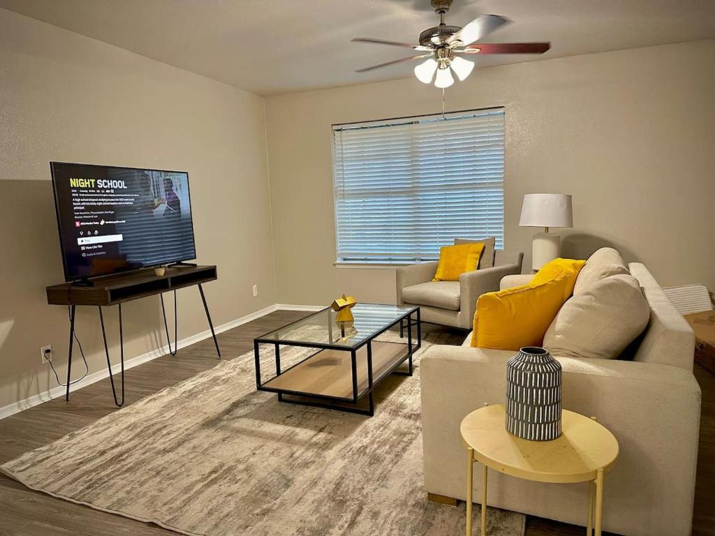 a living room with a couch and a flat screen tv at Townhouse A plus location pool long stay discounts in Sherman