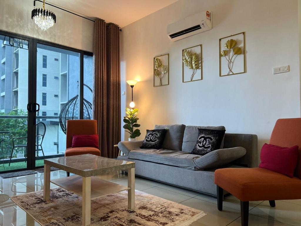 Una sala de estar con un sofá y dos sillas y una mesa. en Cozy Stay Pool Atlantis Residence, en Melaka