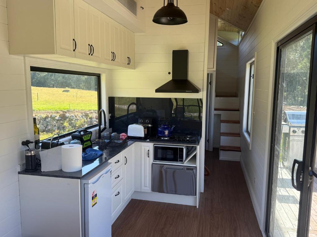 a kitchen in an rv with a sink and a stove at Ferncroft Farm Tiny Home Berry in Wattamolla