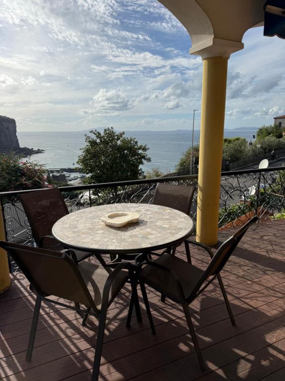 a table and chairs on a balcony with the ocean at White Stylish Apartment 4 in Vico Equense