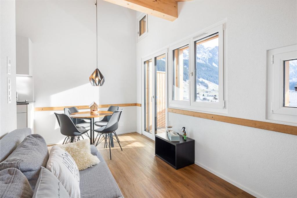 una sala de estar con un sofá y una mesa en Chuenislodge3 neu&stilvoll, 2Balkone, echtes Bijou mit top-Aussicht, en Adelboden