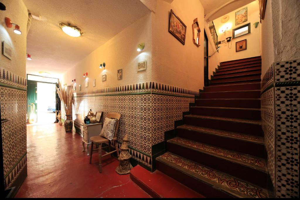 a hallway with stairs in a building with tiles at Maison De L'Orb in Béziers
