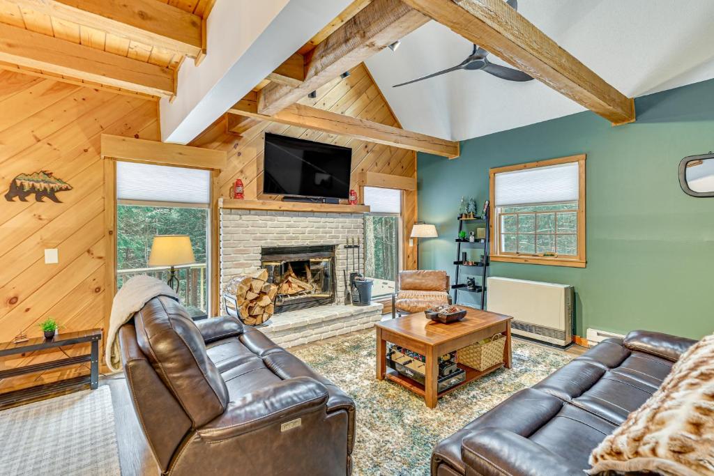 a living room with leather furniture and a fireplace at 8 Mi to Mt Snow Cozy Bear Cabin with Hot Tub! in Wilmington
