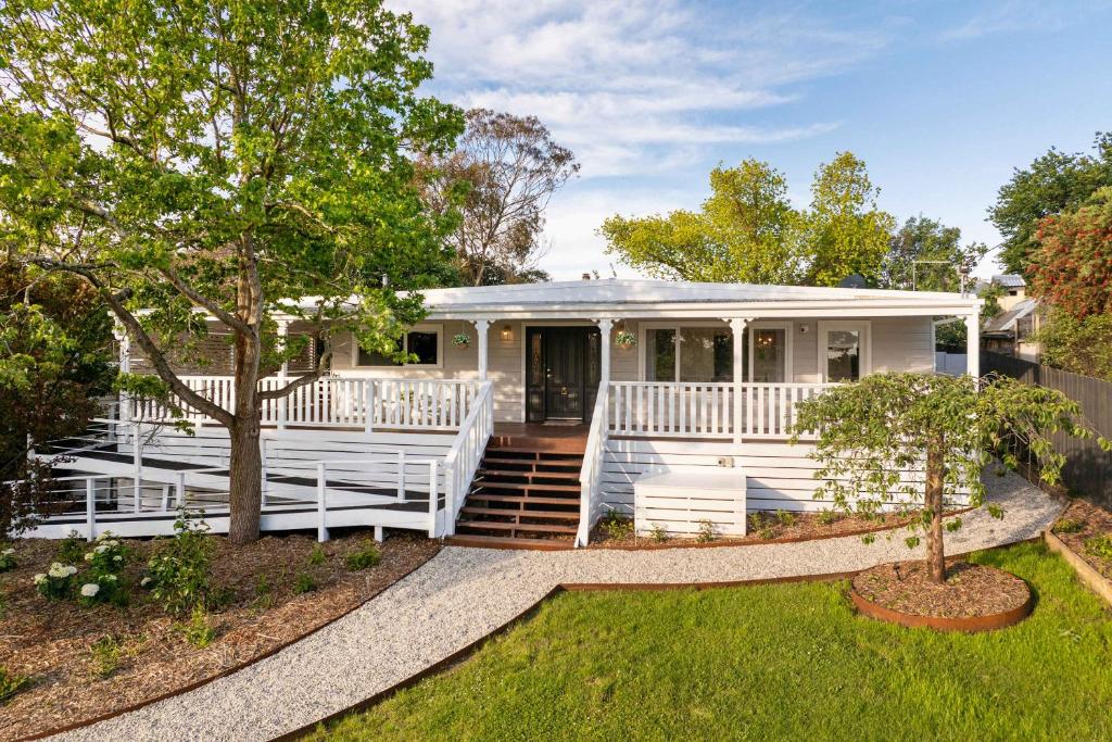 una casa prefabbricata bianca con portico e scale di The Meadow Yarra Valley Large Entertainer with Spa & Sauna a Yarra Glen
