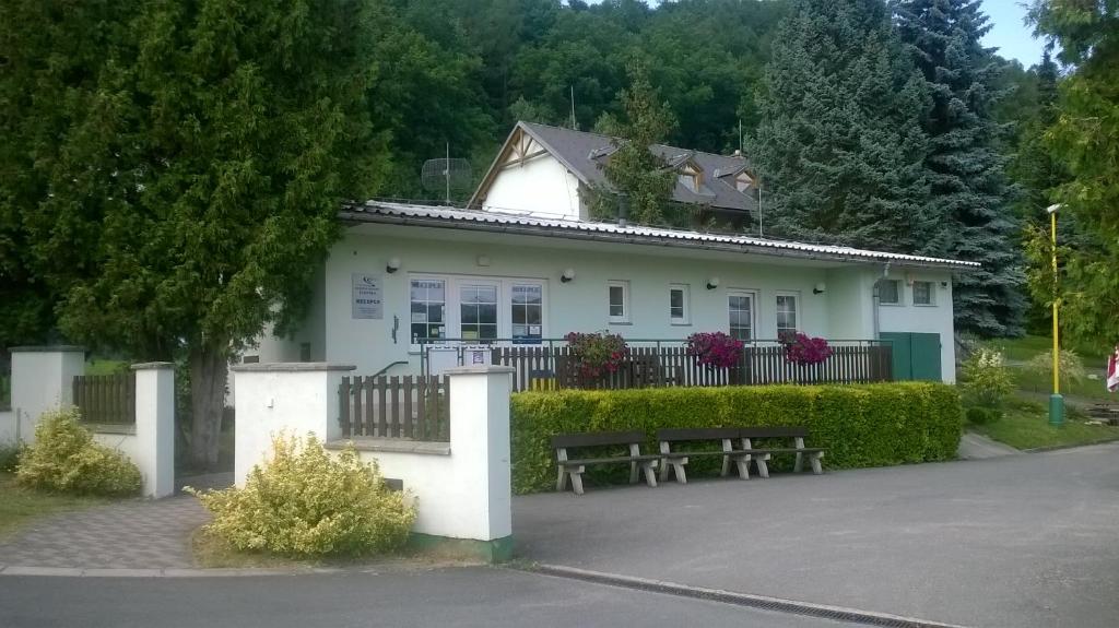 una casa blanca con un banco delante en Rekreační komplex Losinka en Velké Losiny