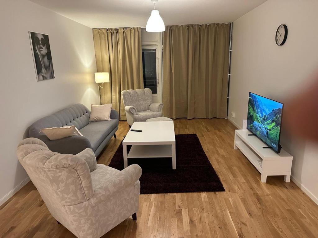 a living room with a couch and chairs and a tv at Noah Longstay Bygatan in Västerås