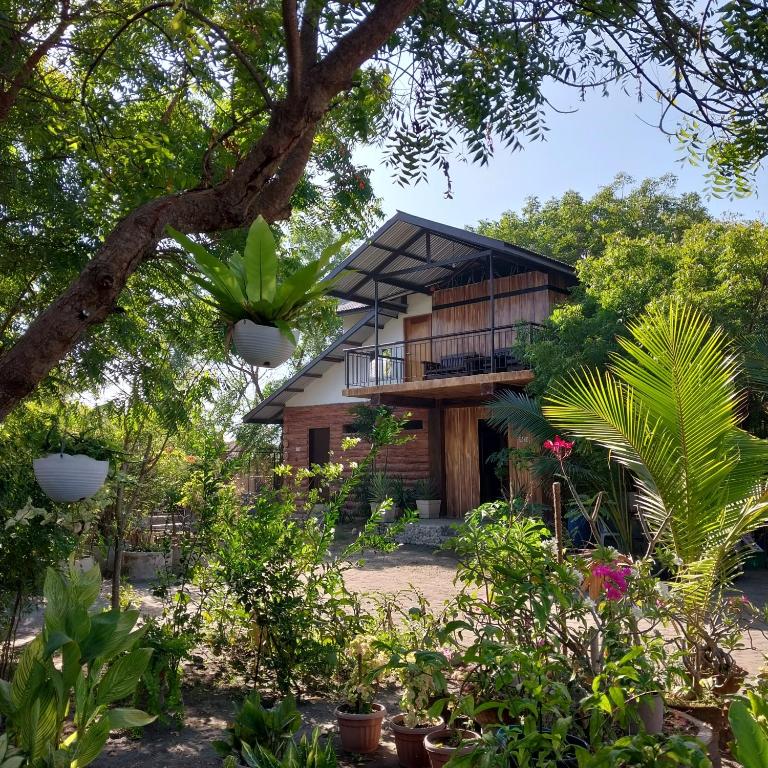 a house surrounded by trees and plants at Beachfront AC Cave Cabin for 10pax in Caba
