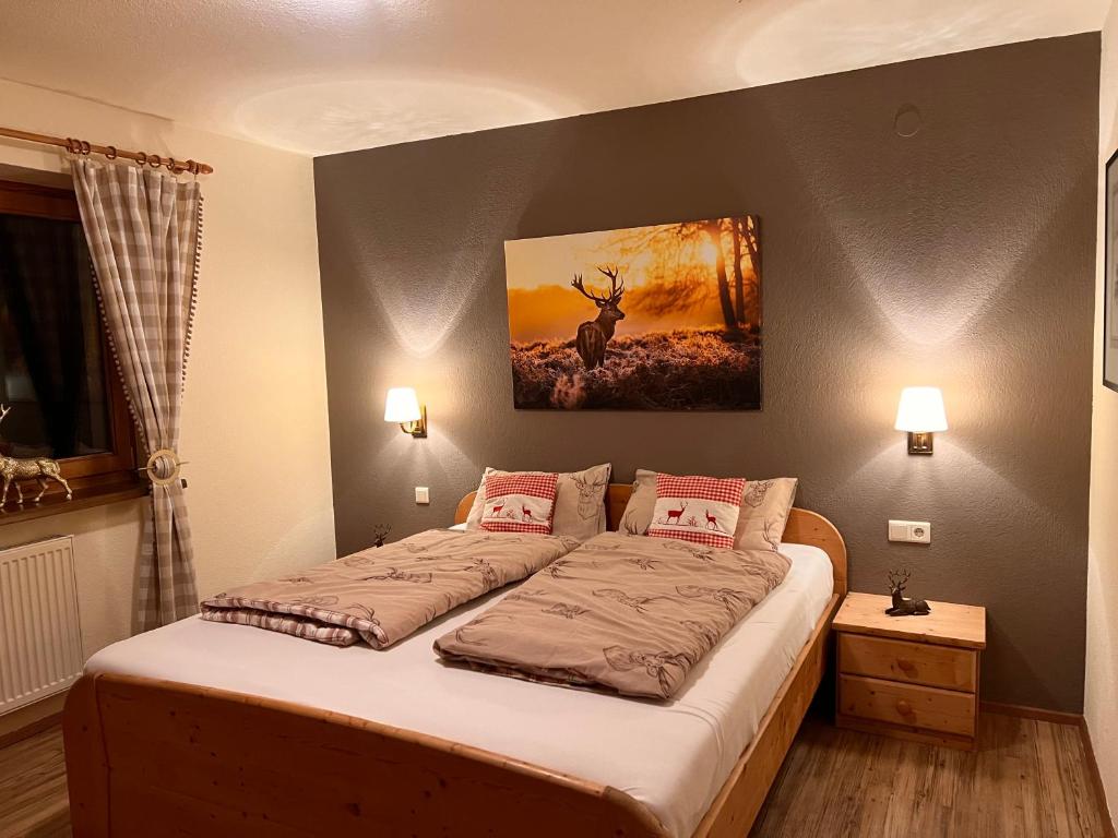 a bedroom with a bed with a painting on the wall at Ferienwohnung Platzhirsch Panorama View Balkon, Gartensauna, Garten, Grillplatz in Stumm